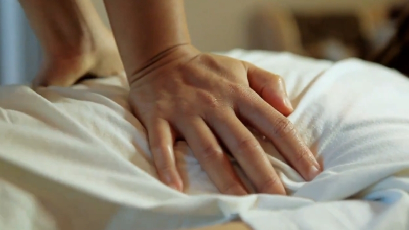 Close-up of a therapist’s hands pressing gently during a massage