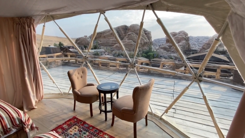 Cozy desert dome with chairs facing a wide rocky landscape